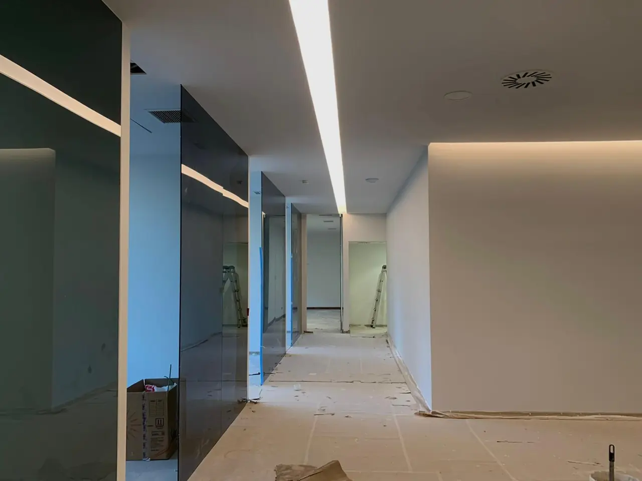 Pasillo con línea de luz: falsos techos de pladur en oficinas. Obra de Docaplac